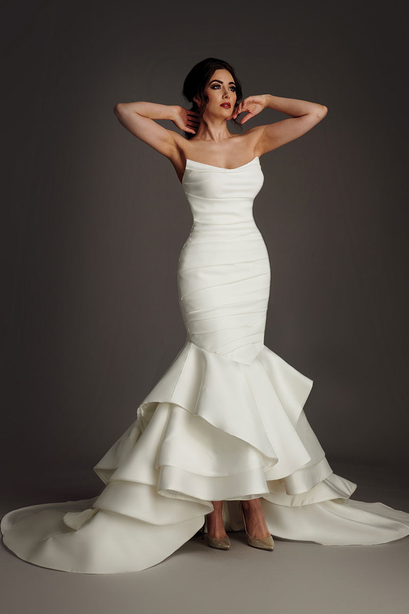 Colby strapless satin wedding dress with ruched bodice and tiered ruffle fishtail skirt.