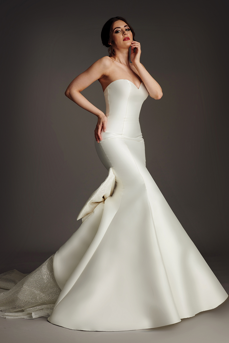 Tyra wedding dress front view showing bateau neck, short sleeves and flared fishtail skirt.