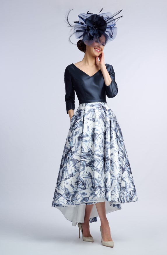 Model in the Aintree navy and white occasion dress with V neckline, three-quarter sleeves and printed high-low skirt