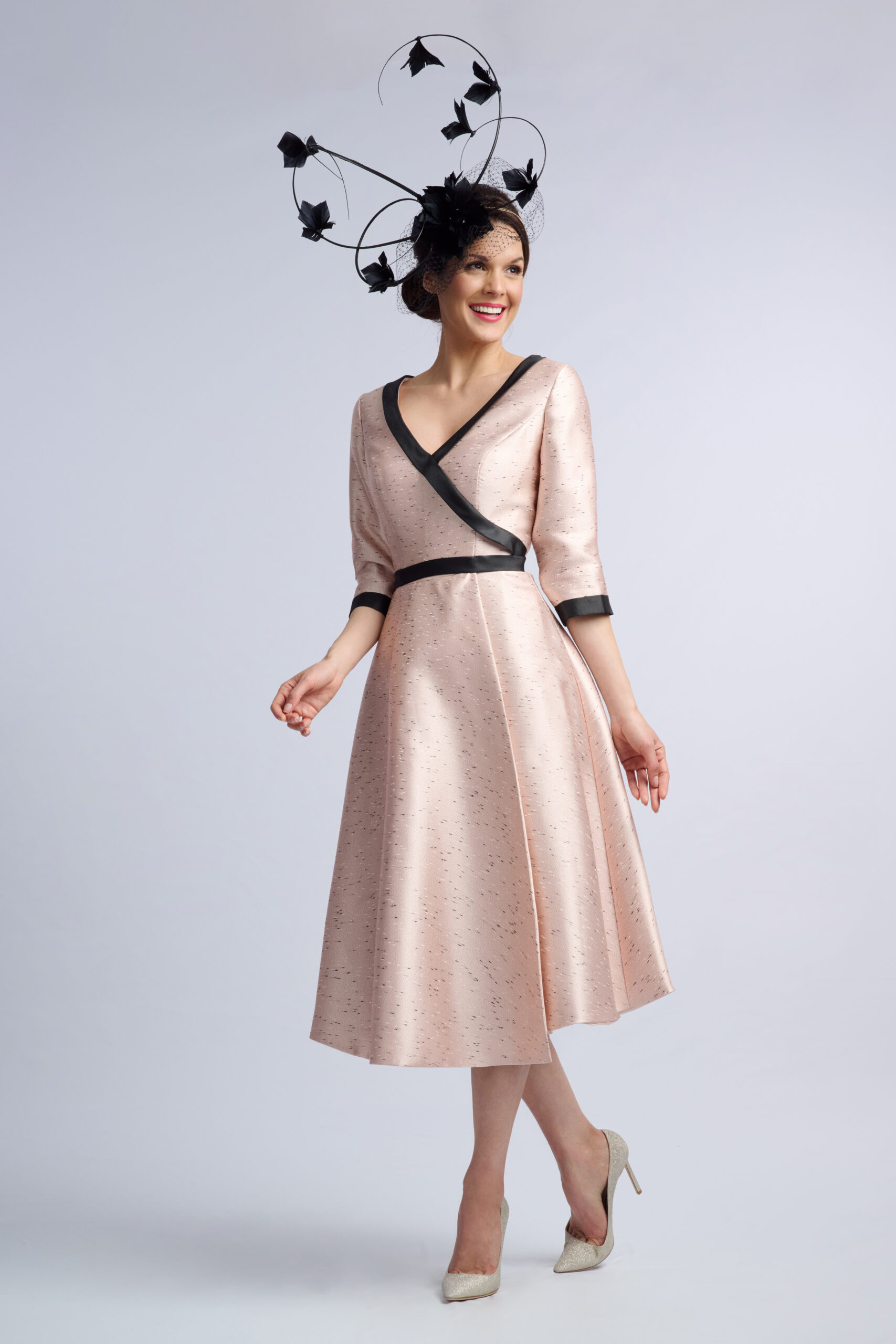 Front view of the Kennington blush occasion dress showing its satin-banded waist and midi-length skirt