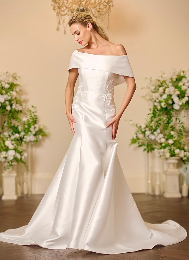 Back view of the Lyla ivory satin fit-and-flare wedding dress with a keyhole back, covered buttons, floral leaf appliqué and a full skirt flowing into a sweeping train.