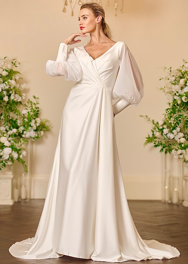 Front view of the Eden ivory satin wedding dress with a high neckline, sheer bishop sleeves, beaded floral appliqué across the shoulders and a full pleated A-line skirt.